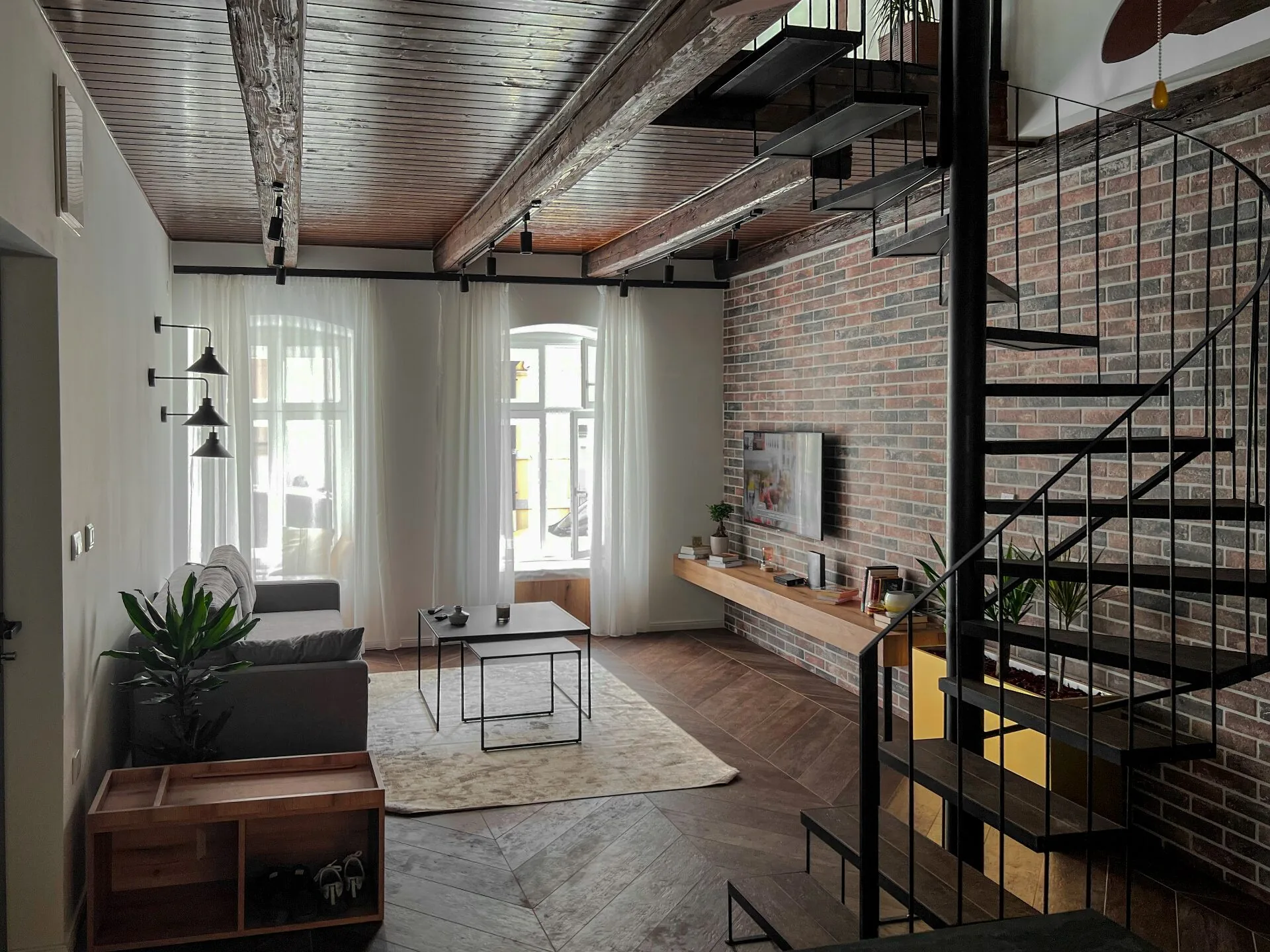 Living room open to the kitchen with spiral staircase and exposed beams